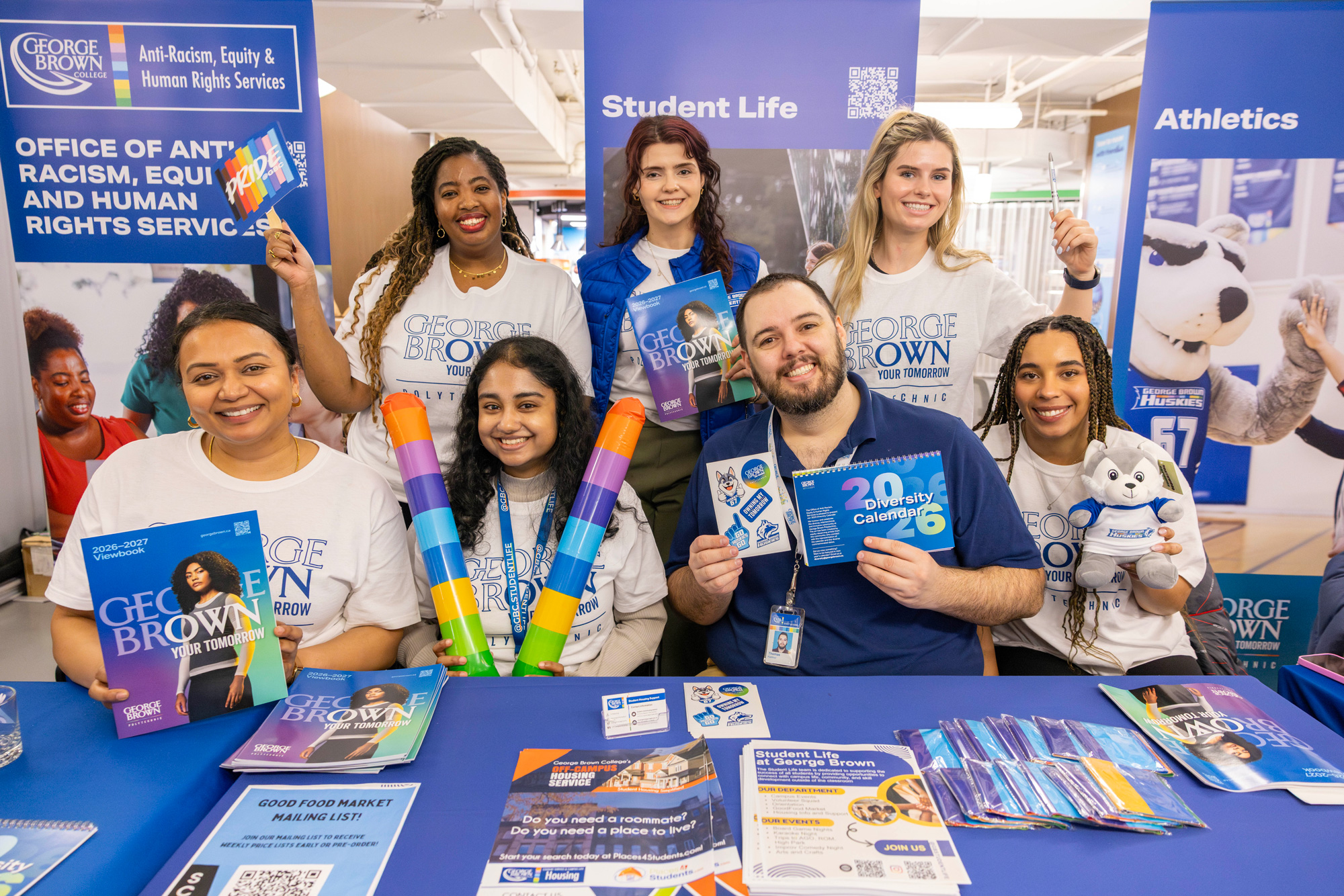 Student success teams hold up materials at the learning support fair