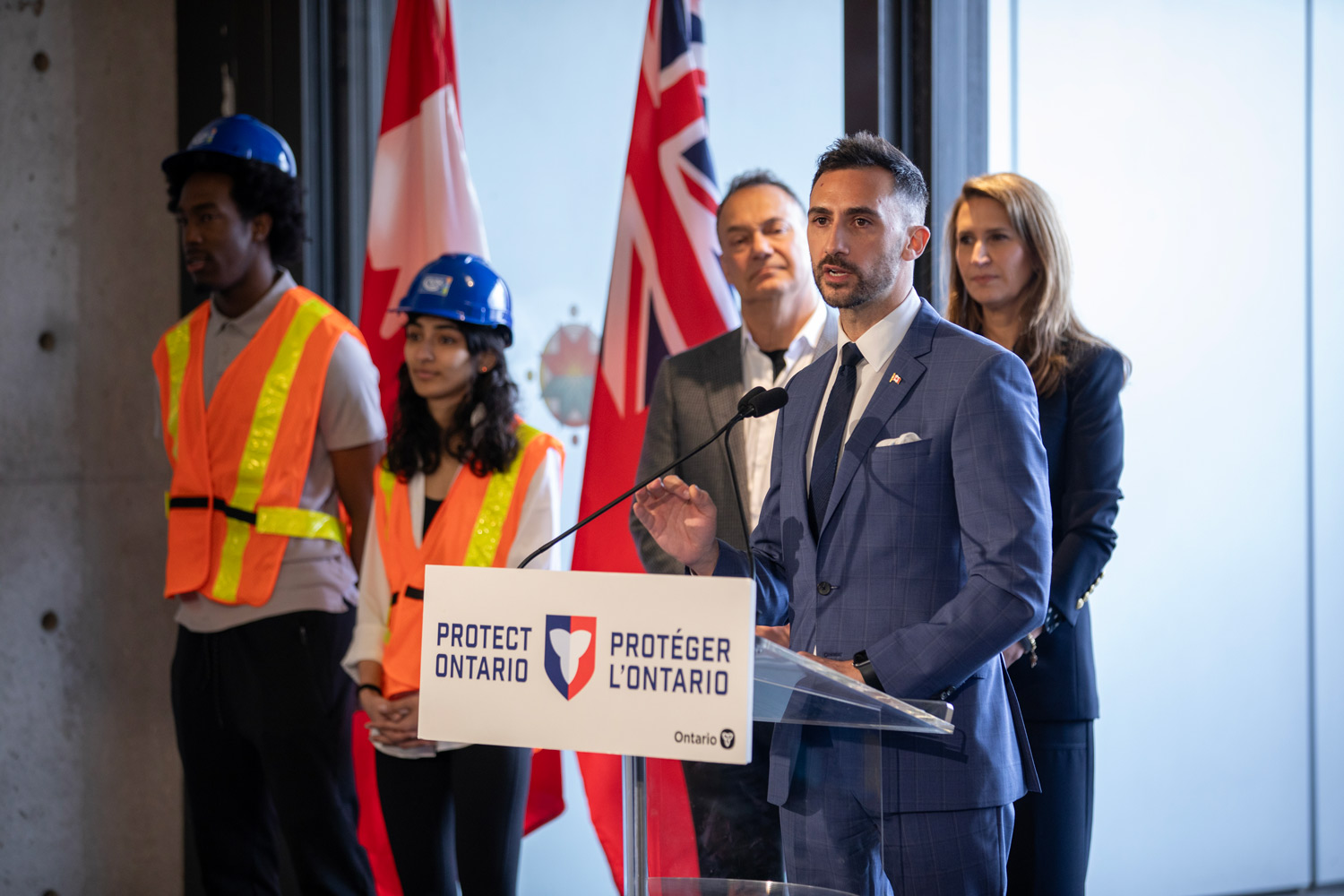 Minister Lecce stands at a podium to announce a $14B private investment in Ontario's economy