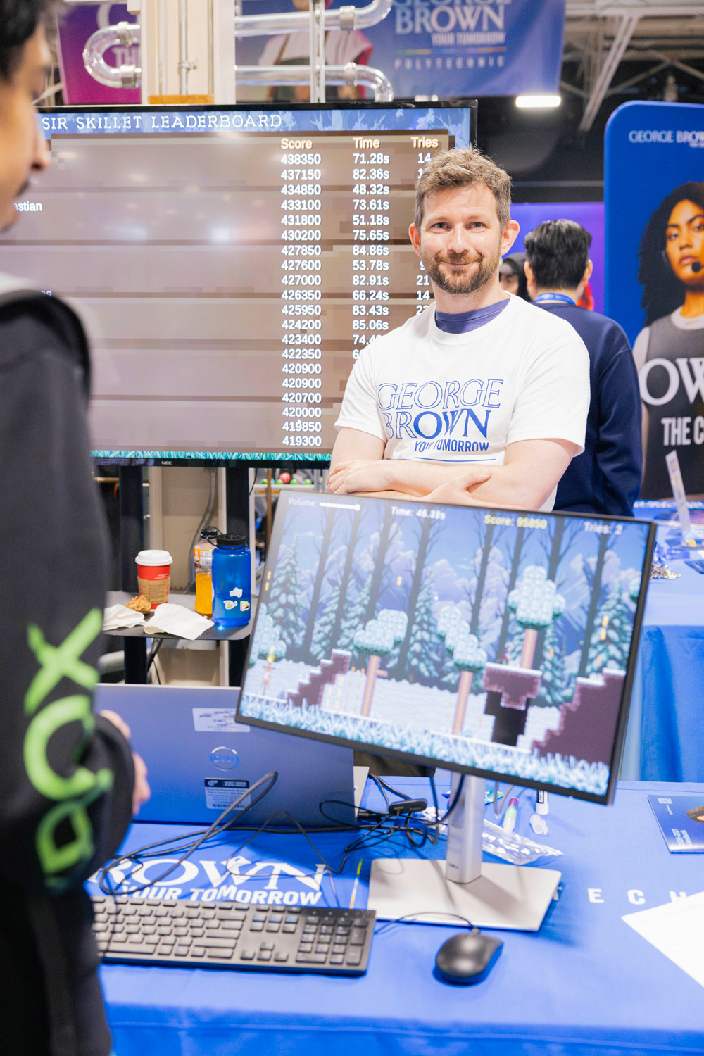 George Brown staff host students playing video games at the Skills Ontario booth.