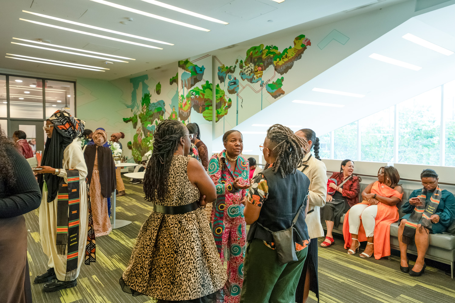 Grads and guests mingle in the lounge at the George Residence for the Legacy in the Making grad event.