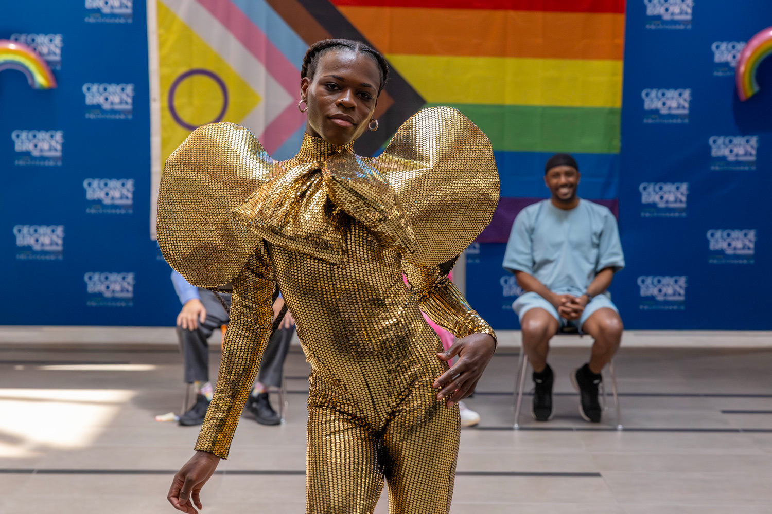 A ballroom performer in gold sequins struts during a ballroom performance at the Pride kickoff event.