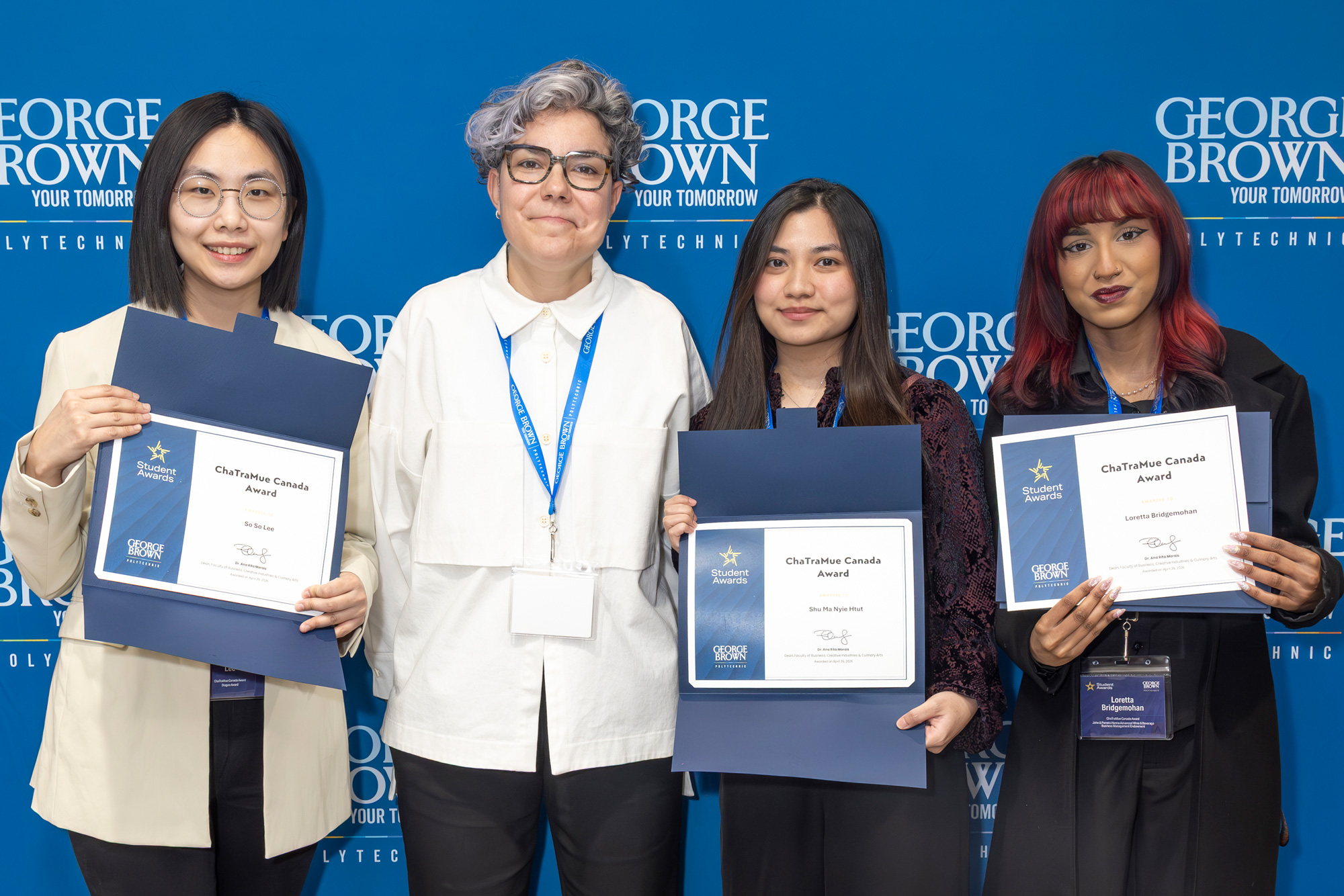 Three 2026 ChaTraMue scholarship recipients pose with Dean Morais.