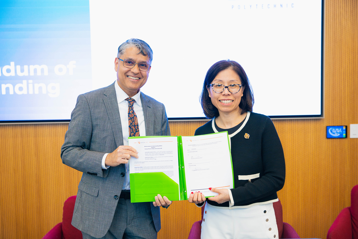 Dr. Hassun Malik holds up a newly signed MOU.