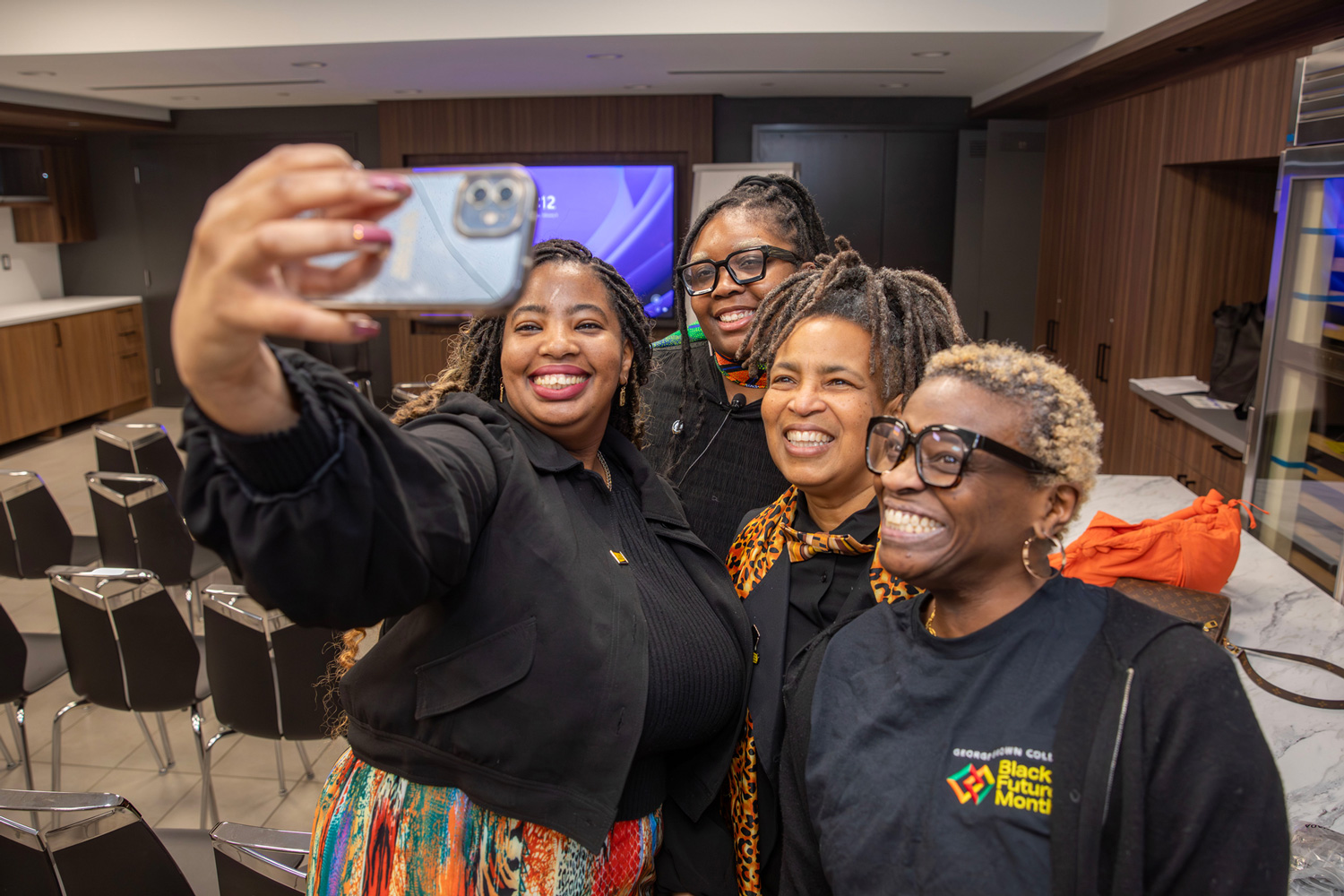 George Brown staff pose together for selfie in Chef School at the Hubbard naming event.