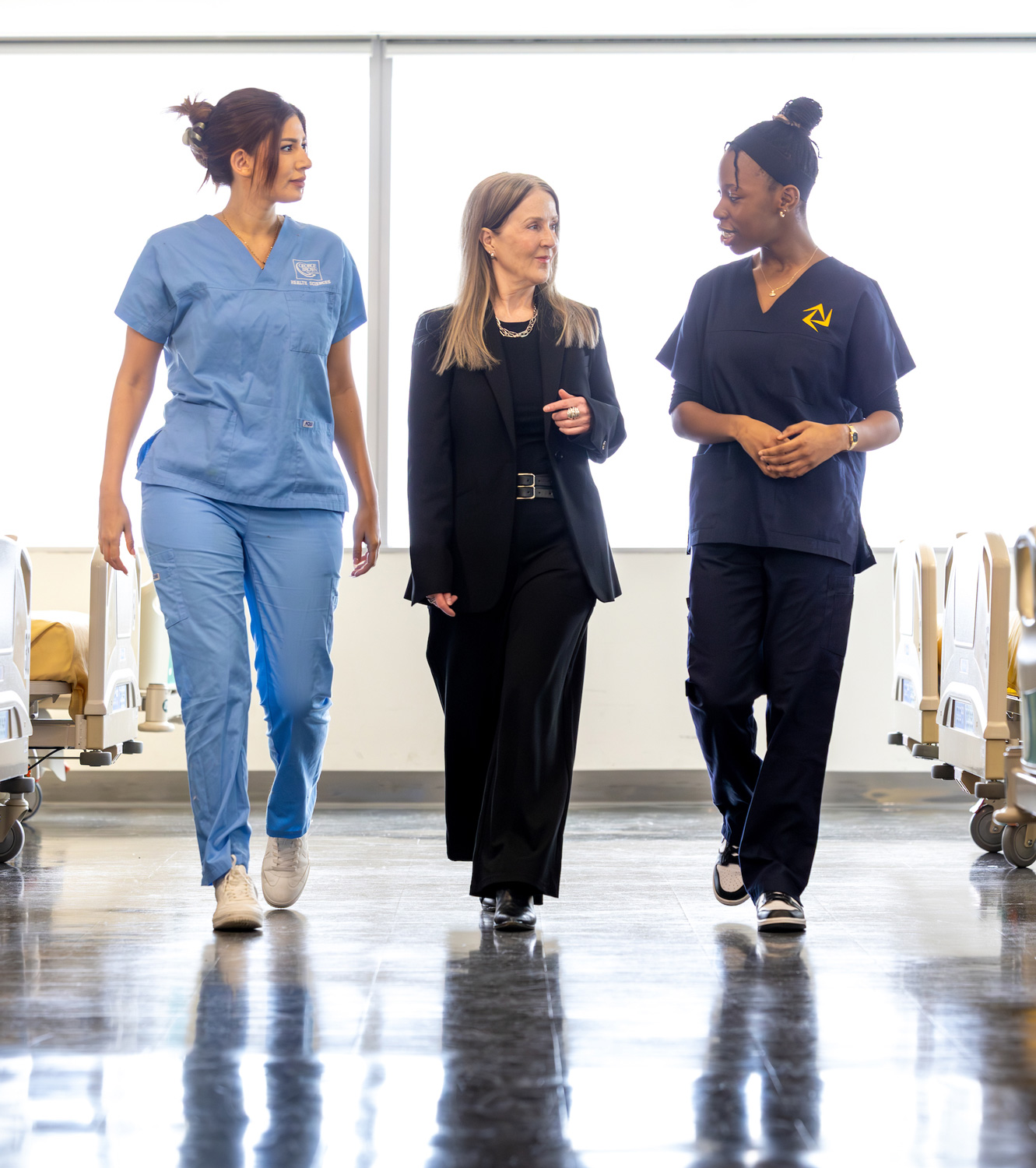 Nursing students walk with Dean of Health Sciences, Dr. Wendy Ellis.