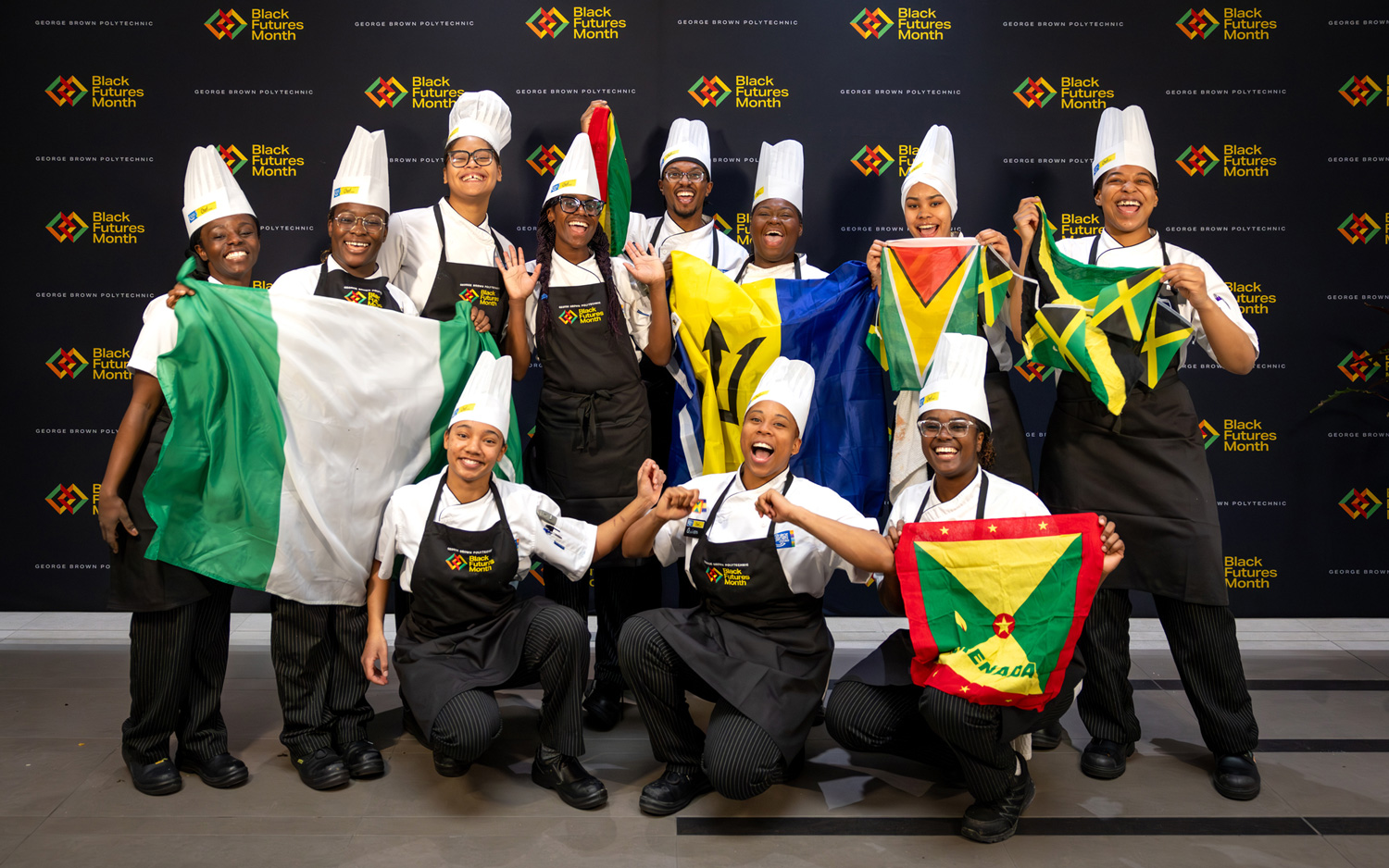 Black Chef School students pose with their flags at the Roots and Recipes culinary event for Black Futures Month.