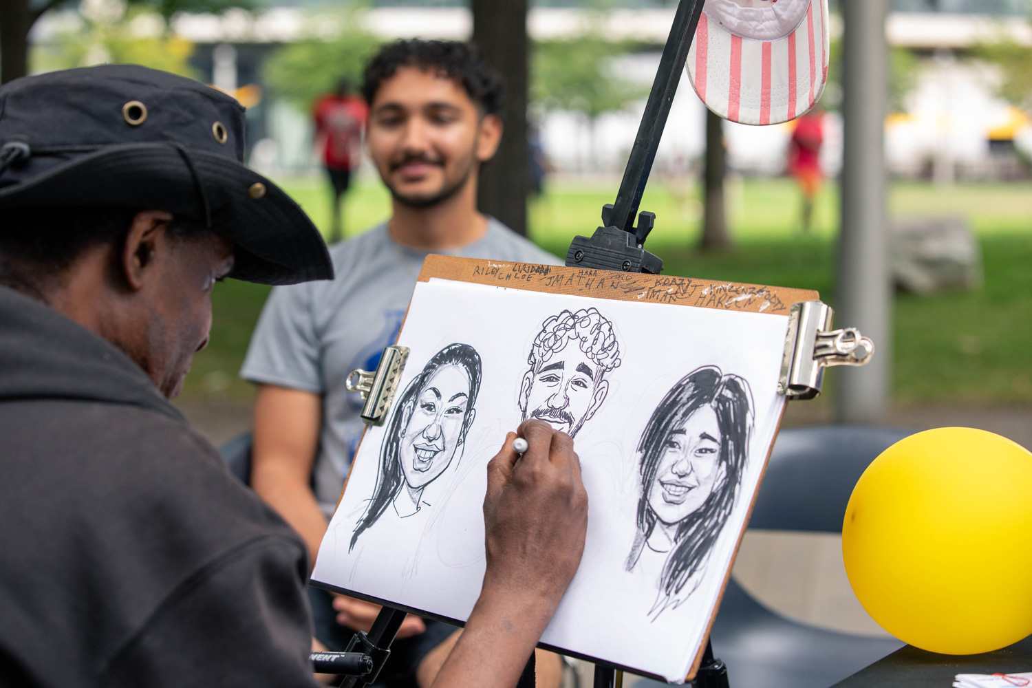 A caricaturist draws guests at the Summer Sounds at George Brown event.