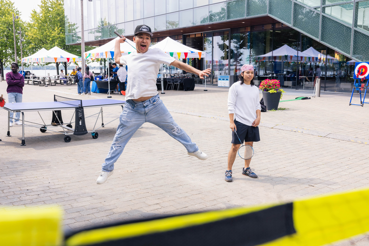 A student jumps in the air while playing badminton at the Summer Sounds event.