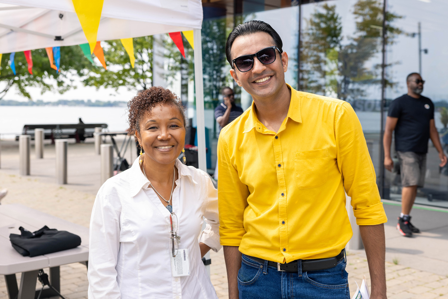 Two smiling George Brown staff outside of the Waterfront Campus at Summer Sounds.