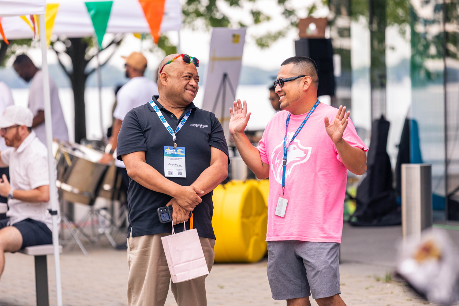 Staff have a chat on the patio at the Summer Sounds event outside of the Waterfront Campus.