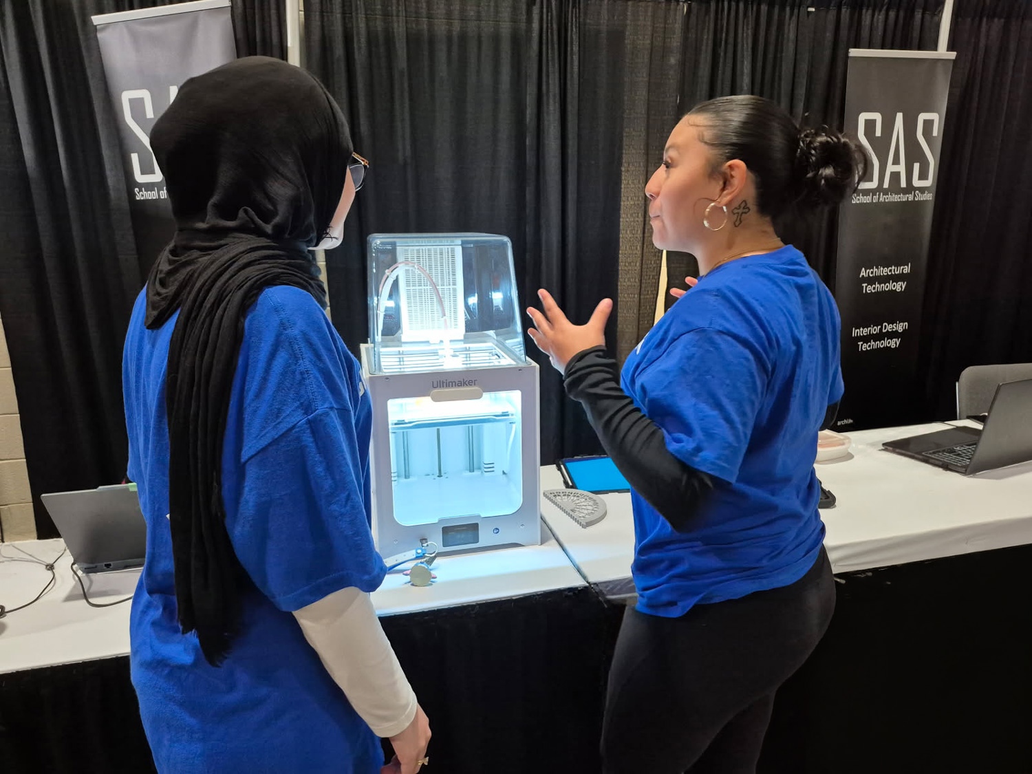 Two architecture students at the CNE use a 3D printer to reproduce scale replacement parts for the Crystal Palace model.