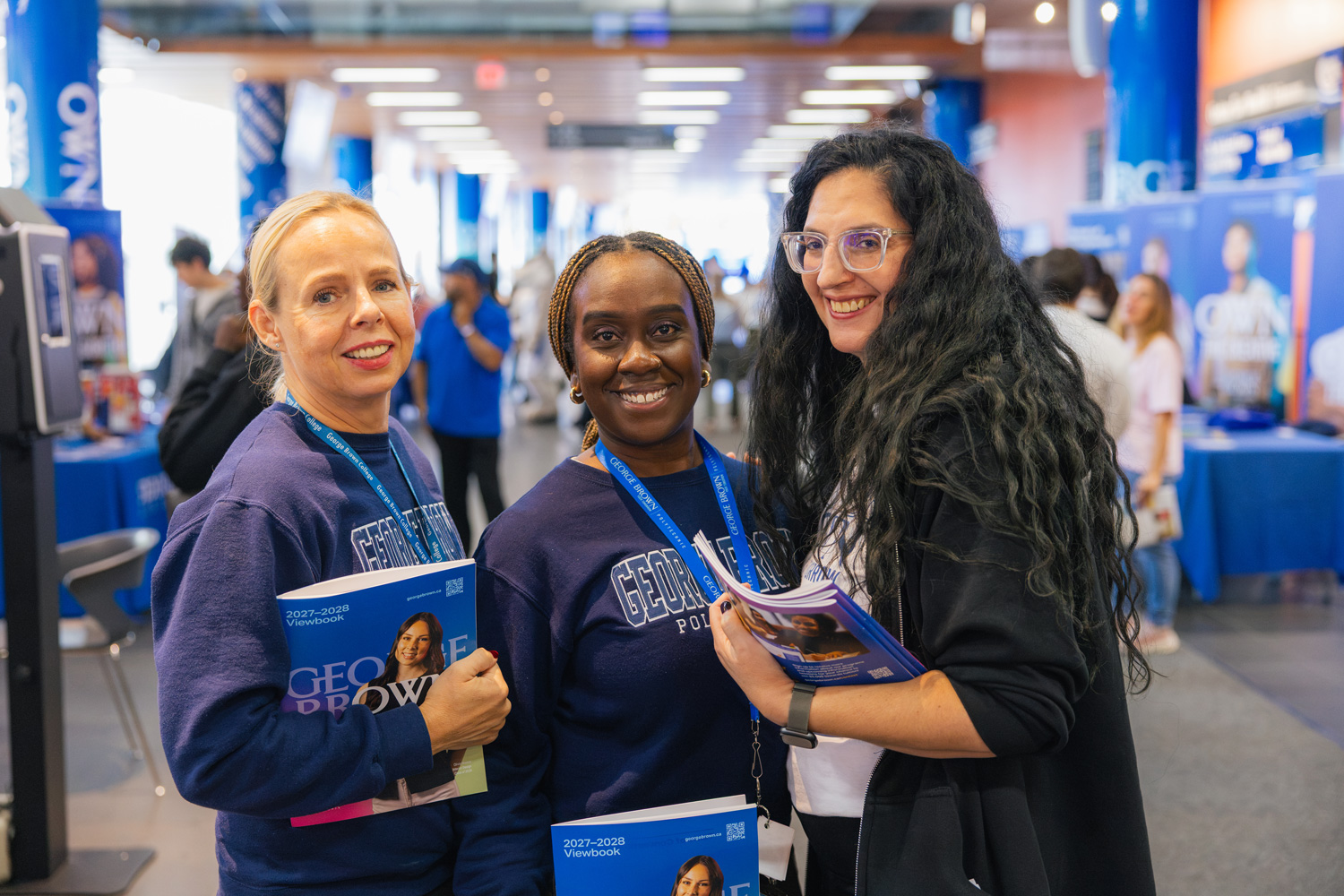 George Brown staff holding view books wearing George Brown apparel at the CIP event.