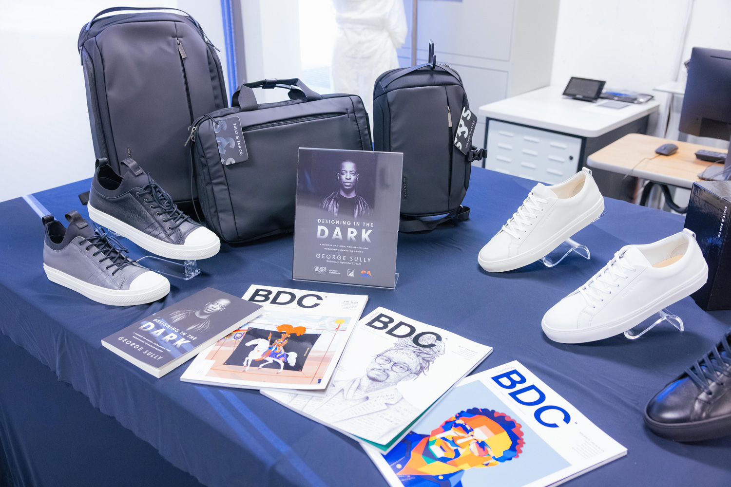 A table displays George Sully's memoir, footwear and accessories, at the alumni event at the Fashion Exchange.