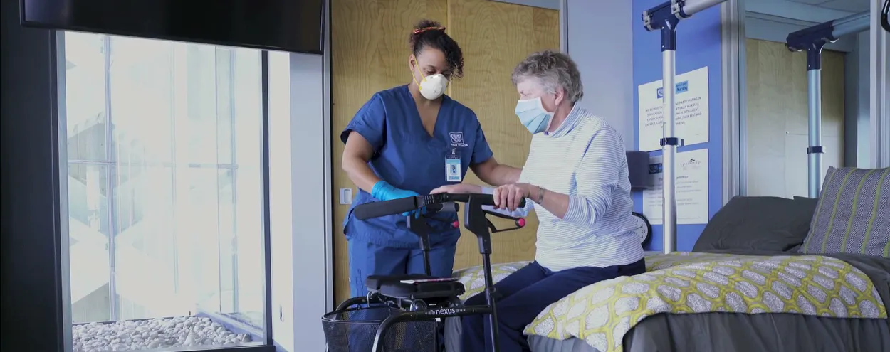 Personal support worker with a senior citizen both wearing masks