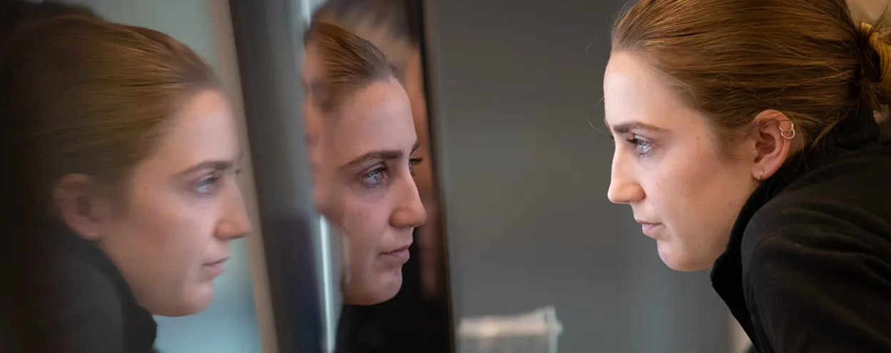Woman staring into computer monitor