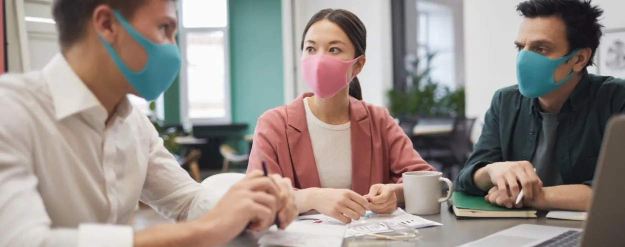 3 people at a desk wearing masks
