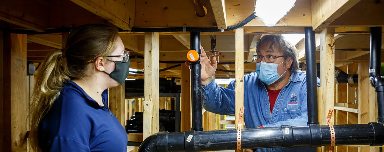 Student and instructor in plumbing lab