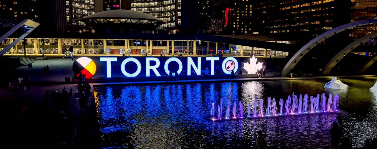 Toronto Sign lit blue at night for George Brown College graduates