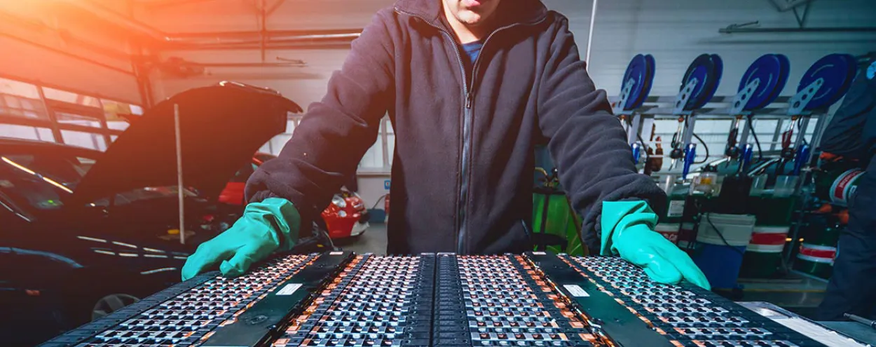 EV Technician in front of car engine