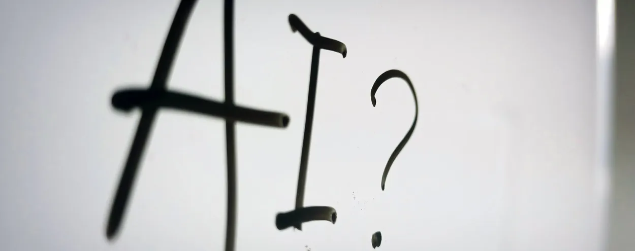 A whiteboard displaying "AI?" in black marker. Photo by Nahrizul Kadri on Unsplash.