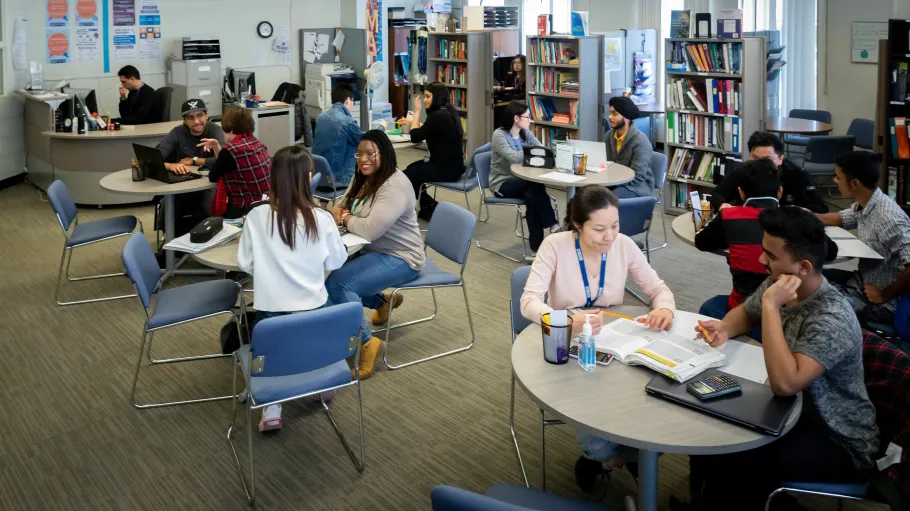 Groups of students studying at small tables