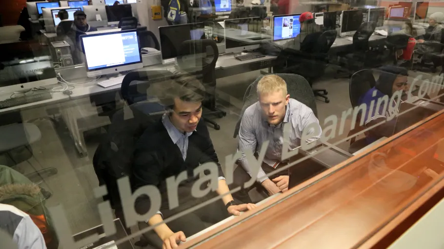 two male students using library computer