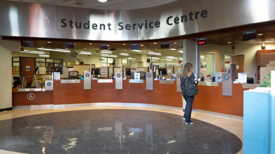 Female student approaching the Student Service Centre information desk at Casa Loma.