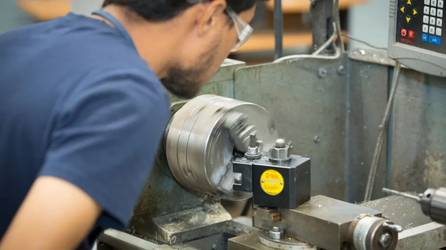 Mechanical engineering student working on a machine in the lab. 