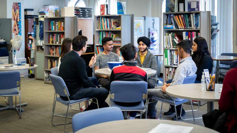 A wide shot of a group of students sitting  together with a  Tutoring and Learning Centre staff during a workshop session.