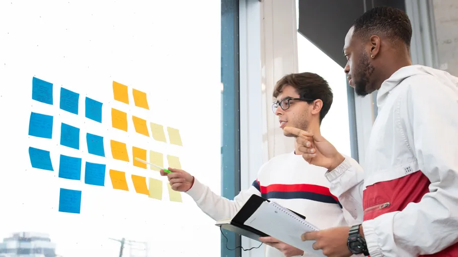 Business alumni students looking at sticky notes on a window