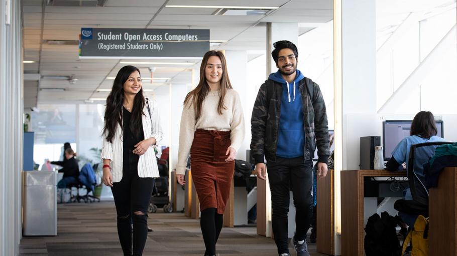 3 students walking through Waterfront Campus library