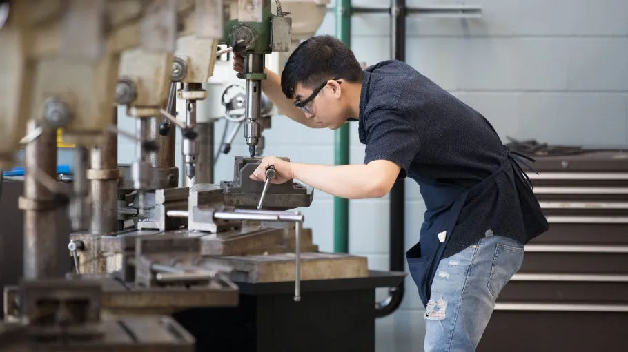 Mechanical engineering student working on a machine in the lab. 