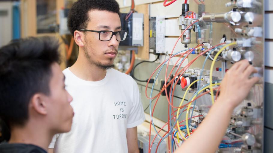Electromechanical students working in the lab on an electro board.