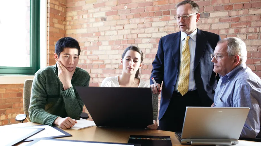 Business students meeting in the workplace with their employer.