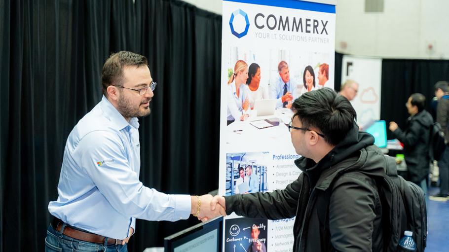 Student shaking employer's hand at a career fair