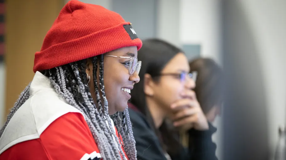 smiling student at computer, shown in profile