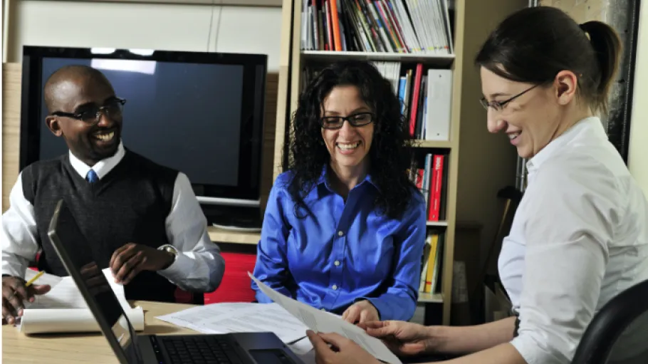 A student works with industry partners at a laptop.