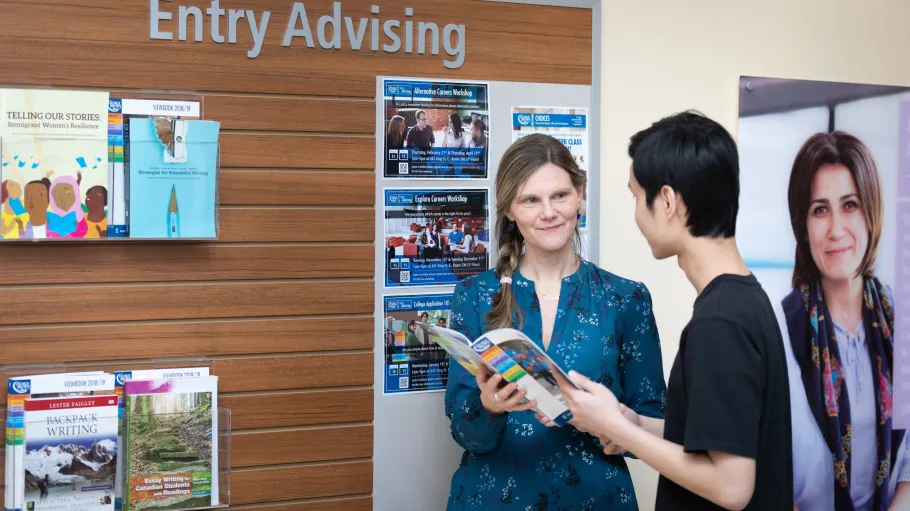 Female Entry Advisor showing a male student a viewbook at Entry Advising.