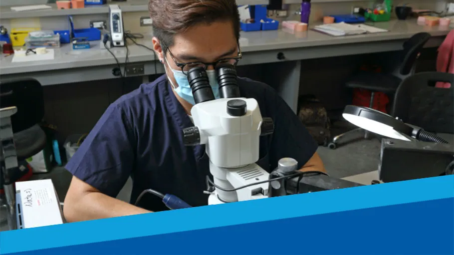 A Dental Technology student uses a microscope.