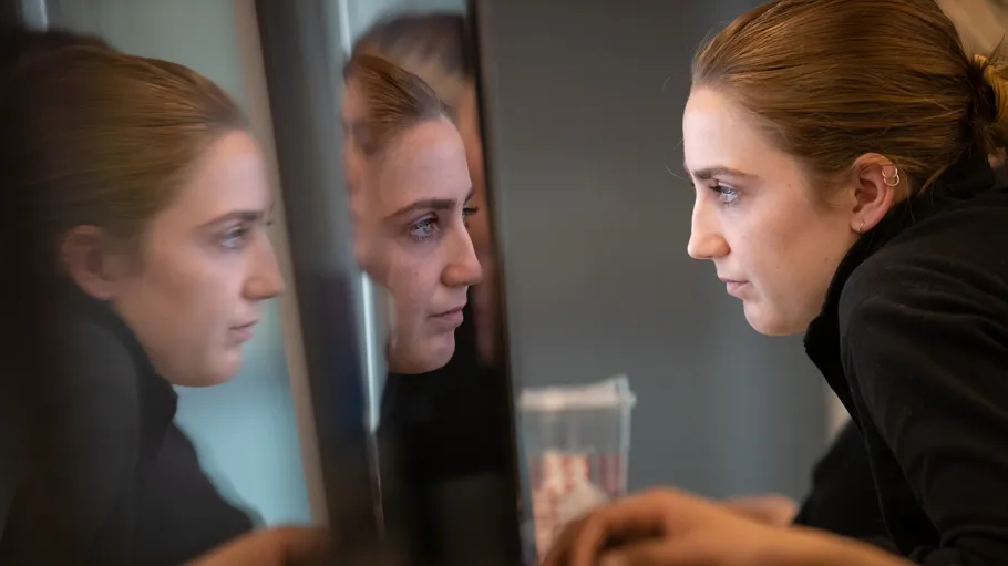 Woman staring into computer monitor