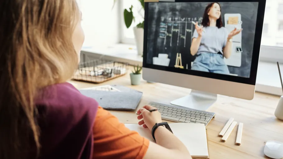 A female student at her computer on an interactive call with an instructor