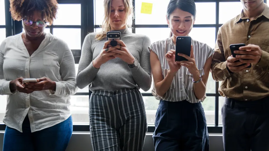 A photo of 4 students on their cellphones