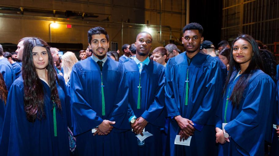 Three male and two female students are posing for the camera at the 2017 convocations.