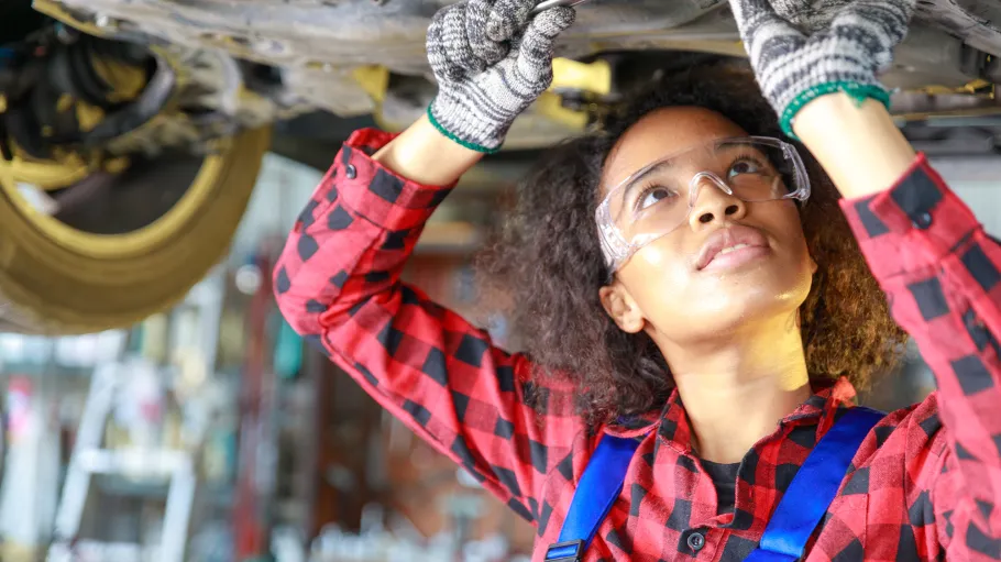 black female student working underneath a vehicle