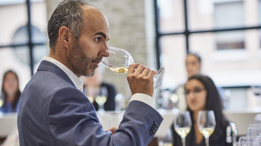 Man smelling glass of white wine at a tasting
