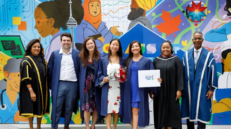 Graduates posing with GBC president after convocation ceremony.