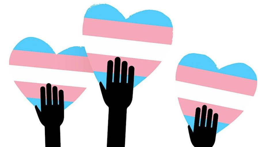 Three hands holding hearts with the Trans flag on them