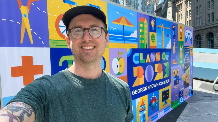 Graphic Design grad Ben O'Neil in front of his convocation mural