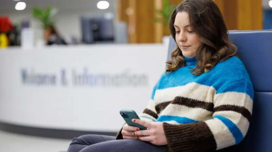Student sitting using their phone
