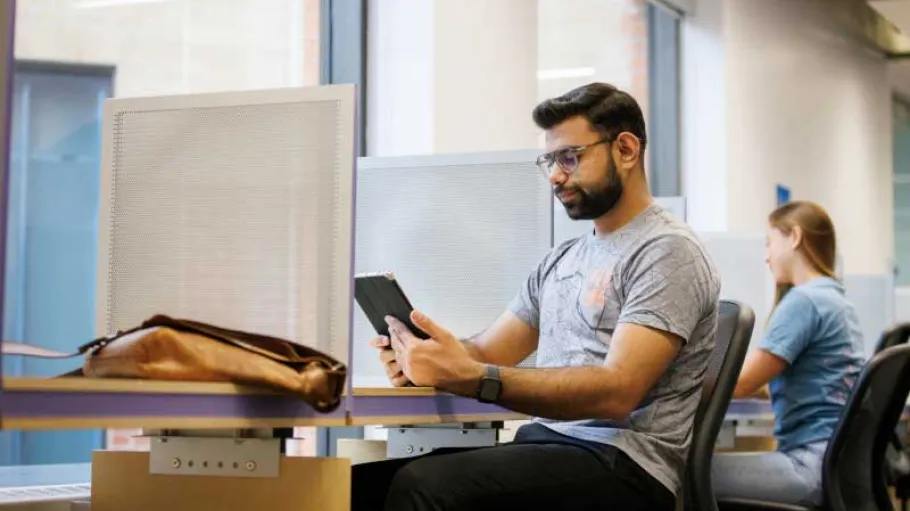 Student at a workstation using a phone